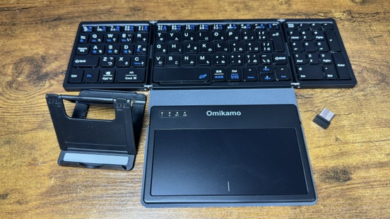 開いた状態の Omikamo 折りたたみキーボード。タッチパッド・スタンド・USBレシーバーと並べたところ