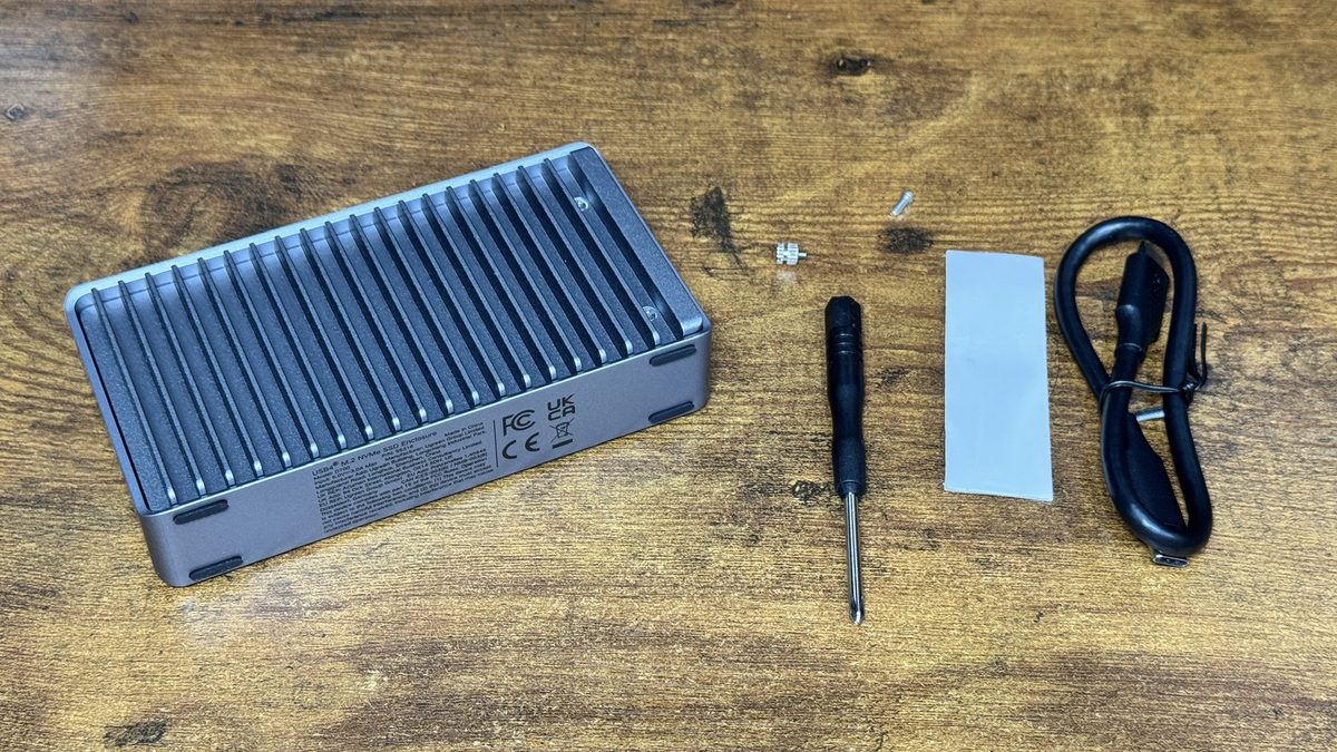 40Gbpsのケースと付属品。左が本体で、右へ順に、ねじとスペーサー、プラスドライバー、熱を伝えるシート、USB-Cケーブルです。